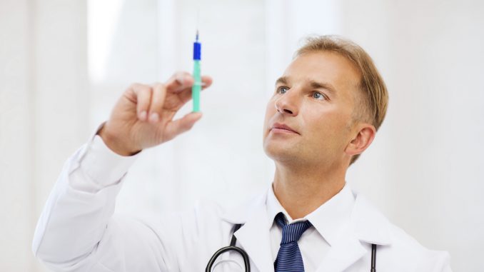 male doctor holding syringe with injection